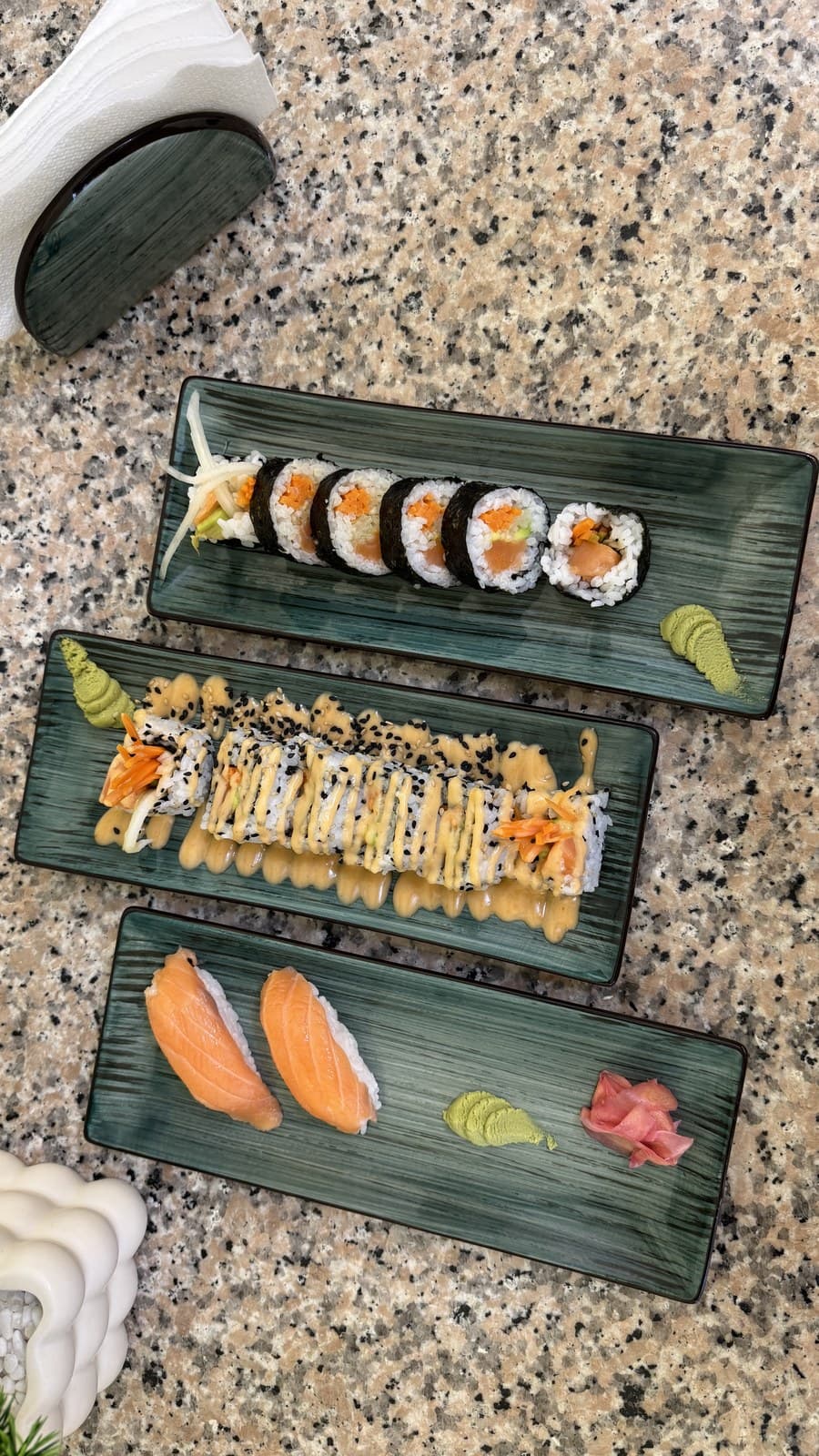 Walan Sushi spread — maki, uramaki and salmon nigiri across three plates