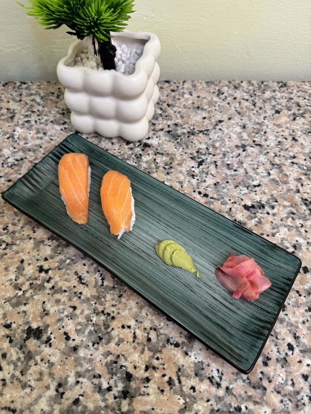 Salmon nigiri on a teal plate